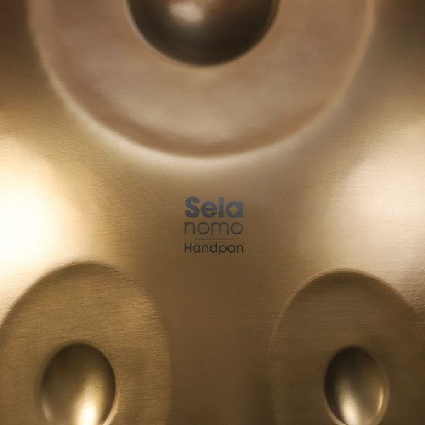 Sela Nomo SEHP400 – הנדפאן D Kurd עם 9 צלילים ותיק 5 Sela Nomo SEHP400 — תקריב לוגו Sela Nomo ומרקם המתכת